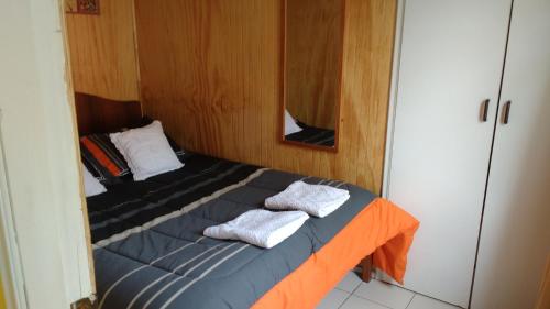 ein kleines Bett in einem Zimmer mit Handtüchern darauf in der Unterkunft Cabaña Don Claudio in Osorno