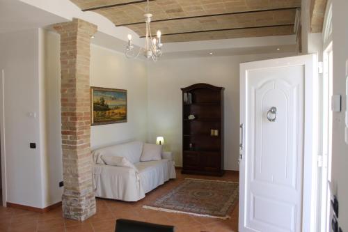 a living room with a white couch and a brick pillar at Il casale di famiglia in Montefalco