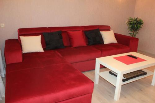a red couch in a living room with a table at Centre-Port apartment in Kherson