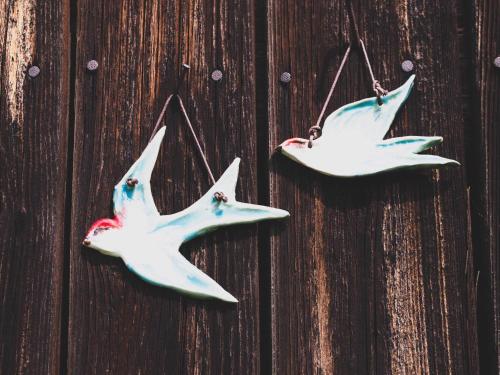 two white birds hanging on a wooden wall at Ubytování NAPOLI in Stará Červená Voda