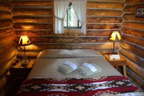 a bedroom with a bed in a log cabin at Escalante Outfitters in Escalante