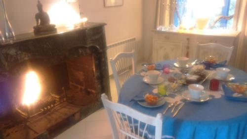 a dining room with a blue table and a fireplace at Chambres d'hôtes Lou Félibre in Vic-la-Gardiole