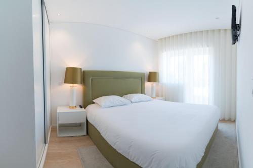 Un dormitorio con una gran cama blanca y una ventana en Bracara Guest House "D. Pedro V" en Braga