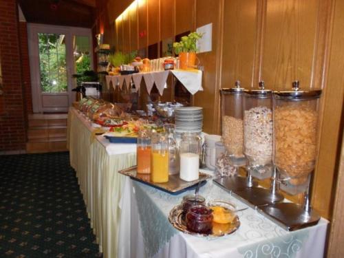 una línea de buffet con mesas con comida y bebida en Hotel Palla, en Essen