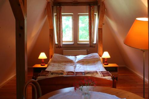 a bedroom with a bed with a table and two lamps at Lisi Dwór in Czarny Młyn