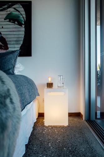 a night stand next to a bed in a room at BULC Boutique Bed & Breakfast in Belmont