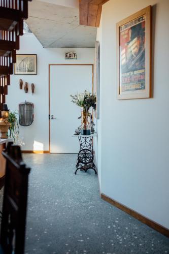 a hallway with a door and a table with flowers at BULC Boutique Bed & Breakfast in Belmont