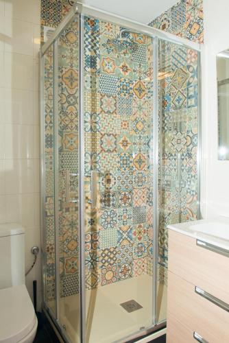 a bathroom with a shower with a tiled wall at Parque del Carmen in Logroño