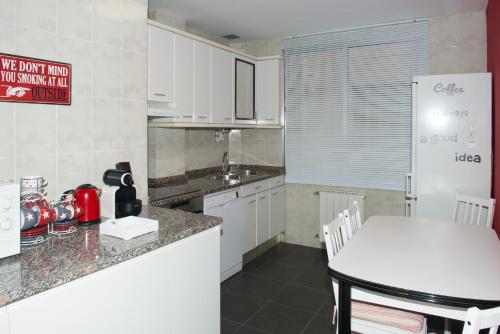 a kitchen with a counter and a white refrigerator at Parque del Carmen in Logroño