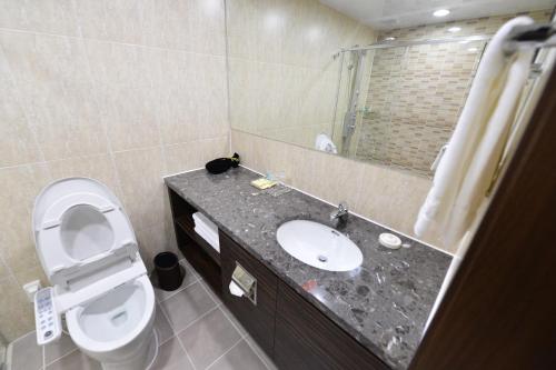 uma casa de banho com um lavatório, um WC e um espelho. em Haeden Hotel High End Suwon em Suwon