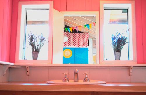 ein Badezimmer mit zwei Fenstern und einem Waschbecken in der Unterkunft Casa Las Moras in San Martín de los Andes