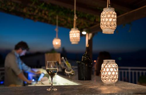 a glass of wine sitting on a bar with lights at Spacious apartment on the beachfront in Melission