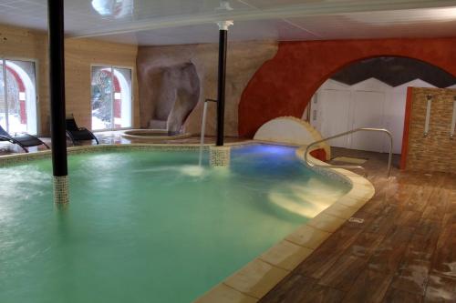 a swimming pool in a room with a swimming pool at Domaine de la Font Vineuse & Spa in Saint-Pierre-dʼArgençon