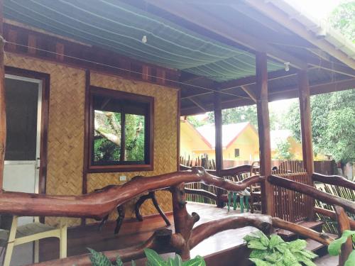 a wooden house with a tree branch on a porch at BING-VICE Tourist Inn in San Vicente