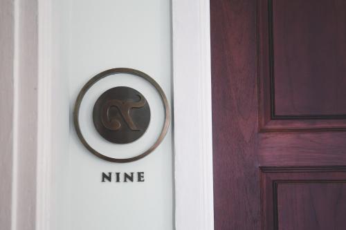 a door with a nine sign on it next to at Baan 2459 Heritage House in Bangkok