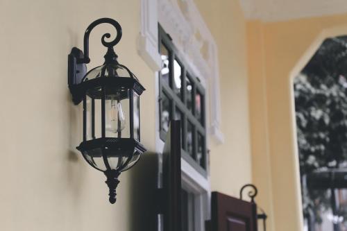 a black lantern hanging on the side of a building at Baan 2459 Heritage House in Bangkok