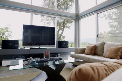a living room with a large tv and a couch at Mighty Mountain Thailand in Kaeng Krachan