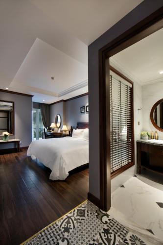a bedroom with a large bed and a desk at La Sinfonía Majesty Hotel and Spa in Hanoi