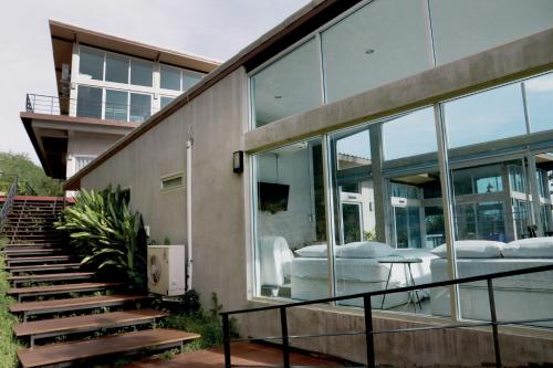 a house with glass windows and a staircase at Mighty Mountain Thailand in Kaeng Krachan