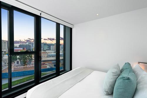 a bedroom with a white bed and a large window at FV by Peppers in Brisbane