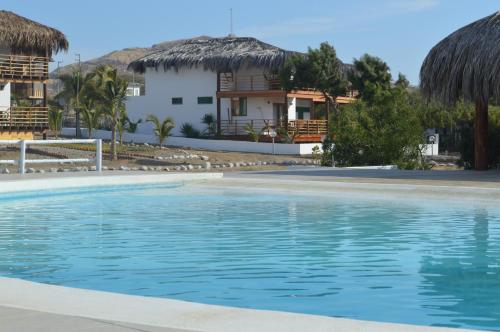 a swimming pool with a house in the background at Casa BlueSky in Los Órganos