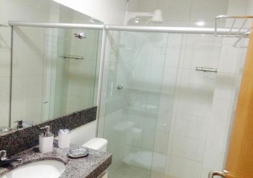 a bathroom with a glass shower and a sink at Flat Carneiros Beach Resort in Praia dos Carneiros