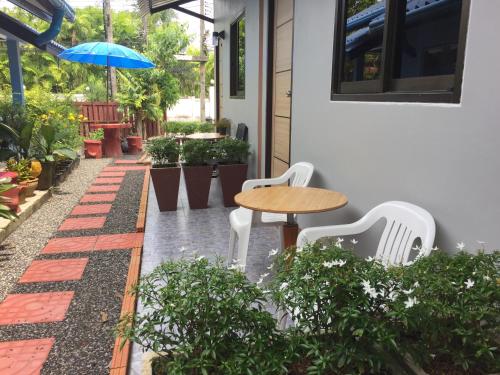 a patio with a table and chairs and an umbrella at Chill land house in Bang Tao Beach
