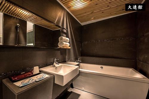 a bathroom with a sink and a bath tub at Roppongi Motel - Dalian in Pingtung City