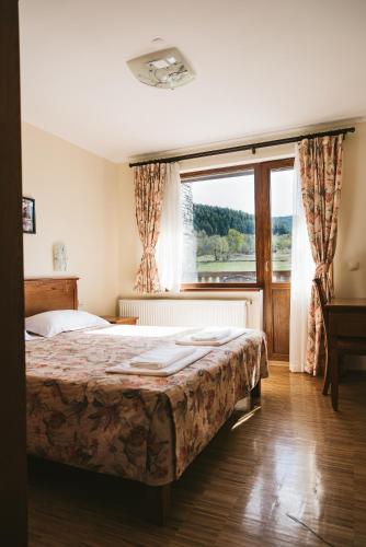 a bedroom with a bed and a large window at Villa Maria, Complex Aleksandria in Dobrinishte