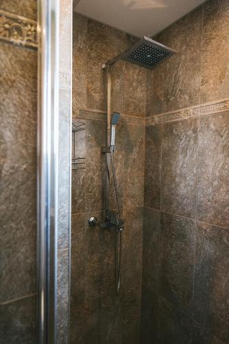 a shower with a shower head in a bathroom at Villa Maria, Complex Aleksandria in Dobrinishte