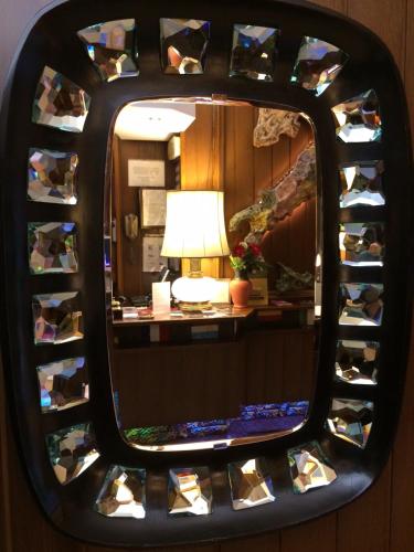 a mirror reflection of a desk with a lamp in a room at Hotel Mec in Milan