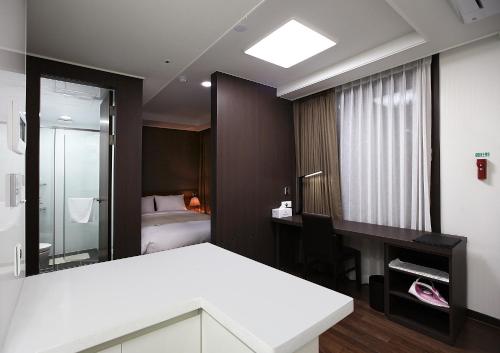 a room with a bed and a desk and a mirror at Urban Place Gangnam in Seoul
