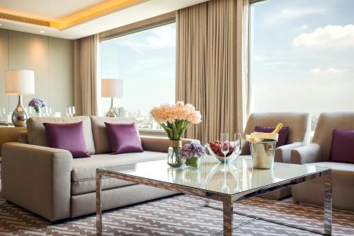 a living room with a couch and a table at Avani Plus Riverside Bangkok Hotel in Bangkok