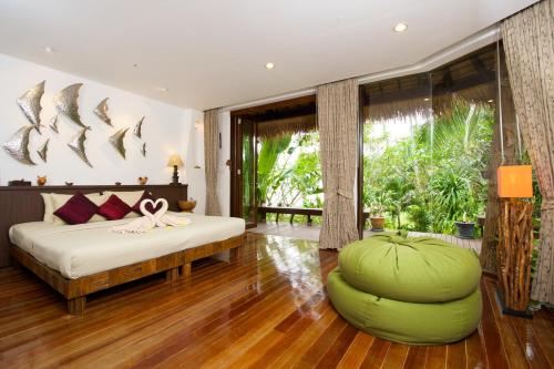 a bedroom with a bed and a large green ottoman at Koh Tao Cabana in Koh Tao