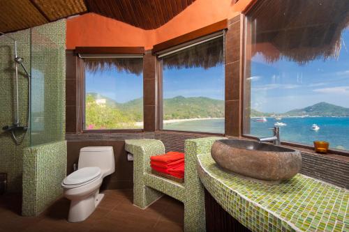 un bagno con lavandino, water e finestra di Koh Tao Cabana a Ko Tao