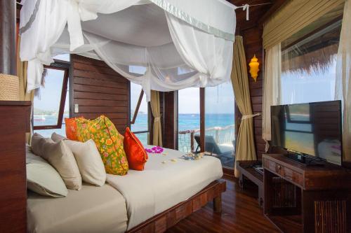 a bedroom with a bed with a television and a window at Koh Tao Cabana in Koh Tao