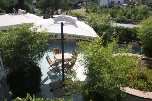 a pool with two chairs and an umbrella at Hotel Cliché in San Lucido