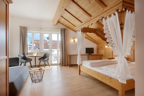 1 dormitorio con 1 cama con techo de madera en Hotel Goldene Rose en Brunico