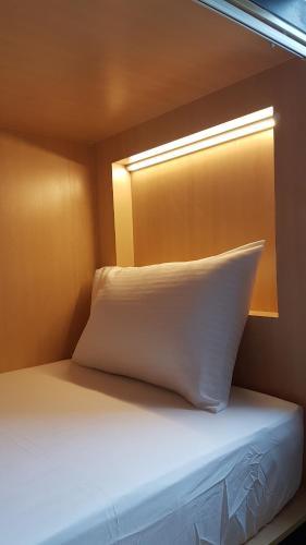 a white pillow sitting on a bed in a room at Hotel 1000 Miles in Kuala Lumpur