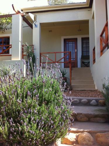 a house with purple flowers in front of it at Koedoeskloof Guesthouse in Ladismith