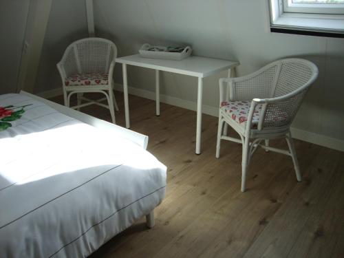 1 dormitorio con 1 cama, mesa y sillas en B&B Hanenberg, en Ooien