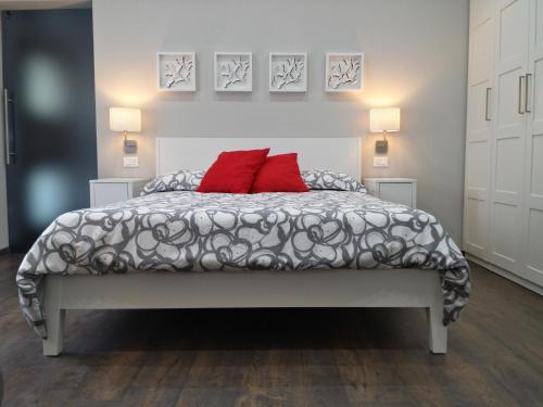 カンネロ・リヴィエーラにあるCasa Luciaのベッドルーム1室(赤い枕2つ付きのベッド1台付)