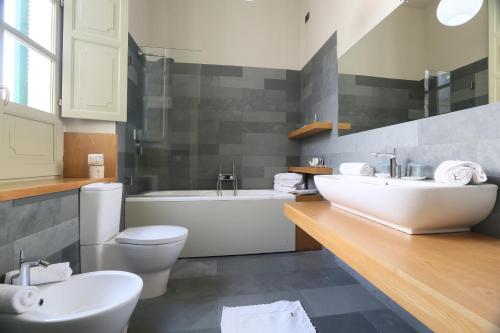 a bathroom with a sink and a tub and a toilet at Residenza d'Epoca Regina d'Arborea in Oristano