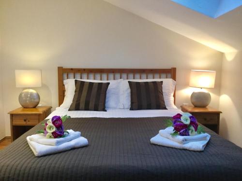 a bedroom with a bed with towels and two lamps at Apartments Plazs 41 in Sukošan