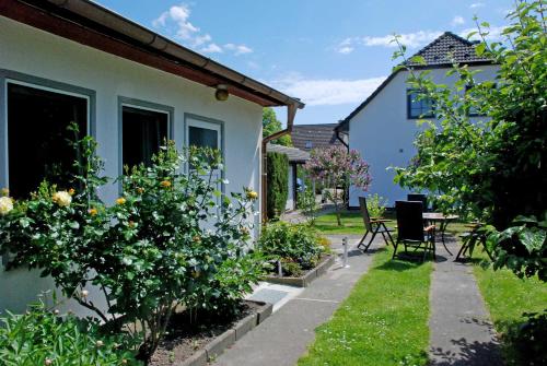 アルテフェーアにあるBungalow in Altefaehrの家とテーブルと椅子のある庭園