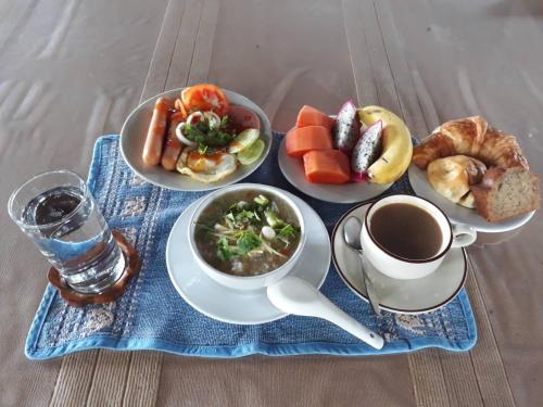 een tafel met borden eten en een kopje koffie bij Khum Khun Wang Resort in Mae Wang