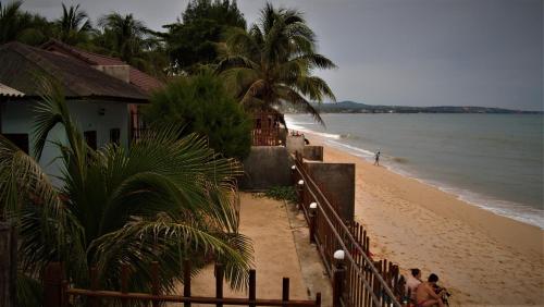 a beach with a house and people walking on the sand at Hong Di Guesthouse in Mui Ne