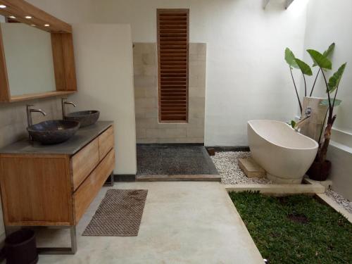 La salle de bains est pourvue d'un lavabo et d'une baignoire. dans l'établissement Blue Garden Yogyakarta, à Yogyakarta