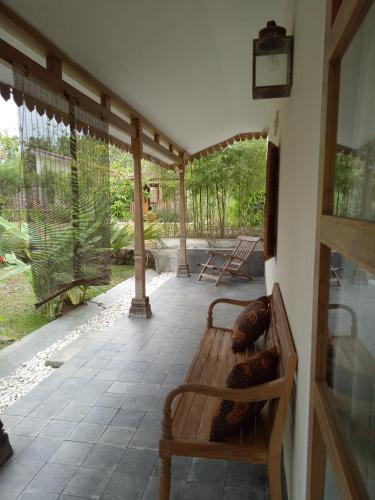 a porch with a wooden bench on a patio at Blue Garden Yogyakarta in Yogyakarta