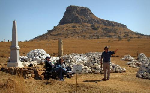 a man standing in front of a pile of rocks at Fugitives Drift Guest House in Rorkeʼs Drift